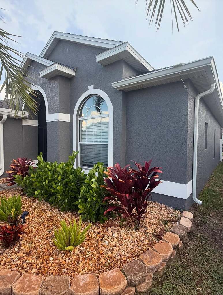 Modern gray house with elegant arches and landscaped garden