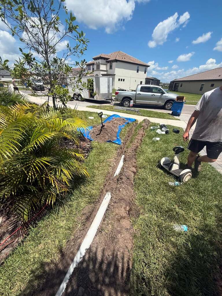 Residential landscaping with exposed irrigation pipes and tools