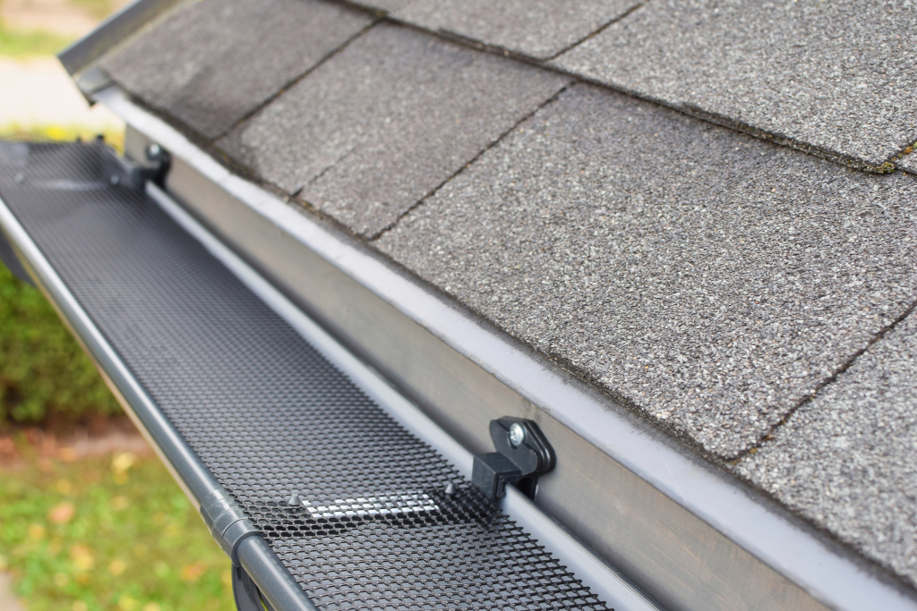 Close-up of a roof gutter with mesh guard installation