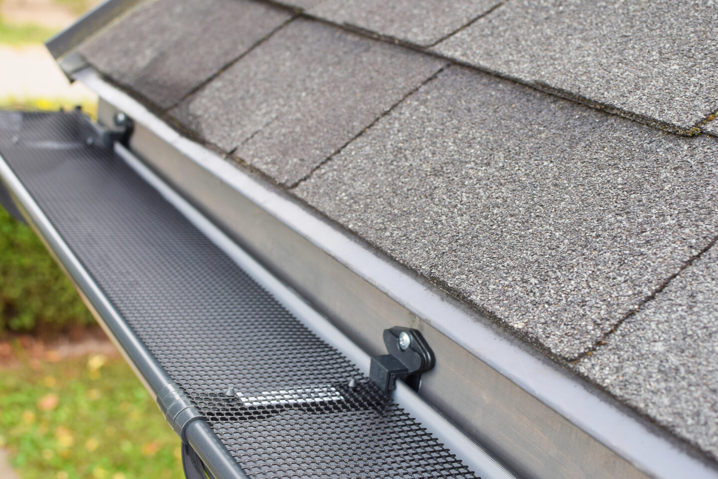 Close-up of a roof gutter with mesh guard installation