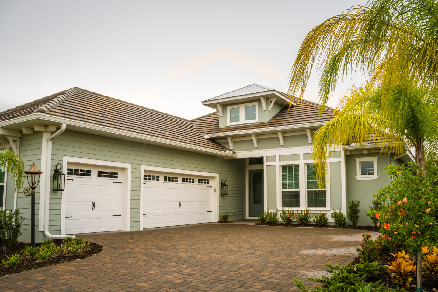 Modern suburban house with double garage and palm trees