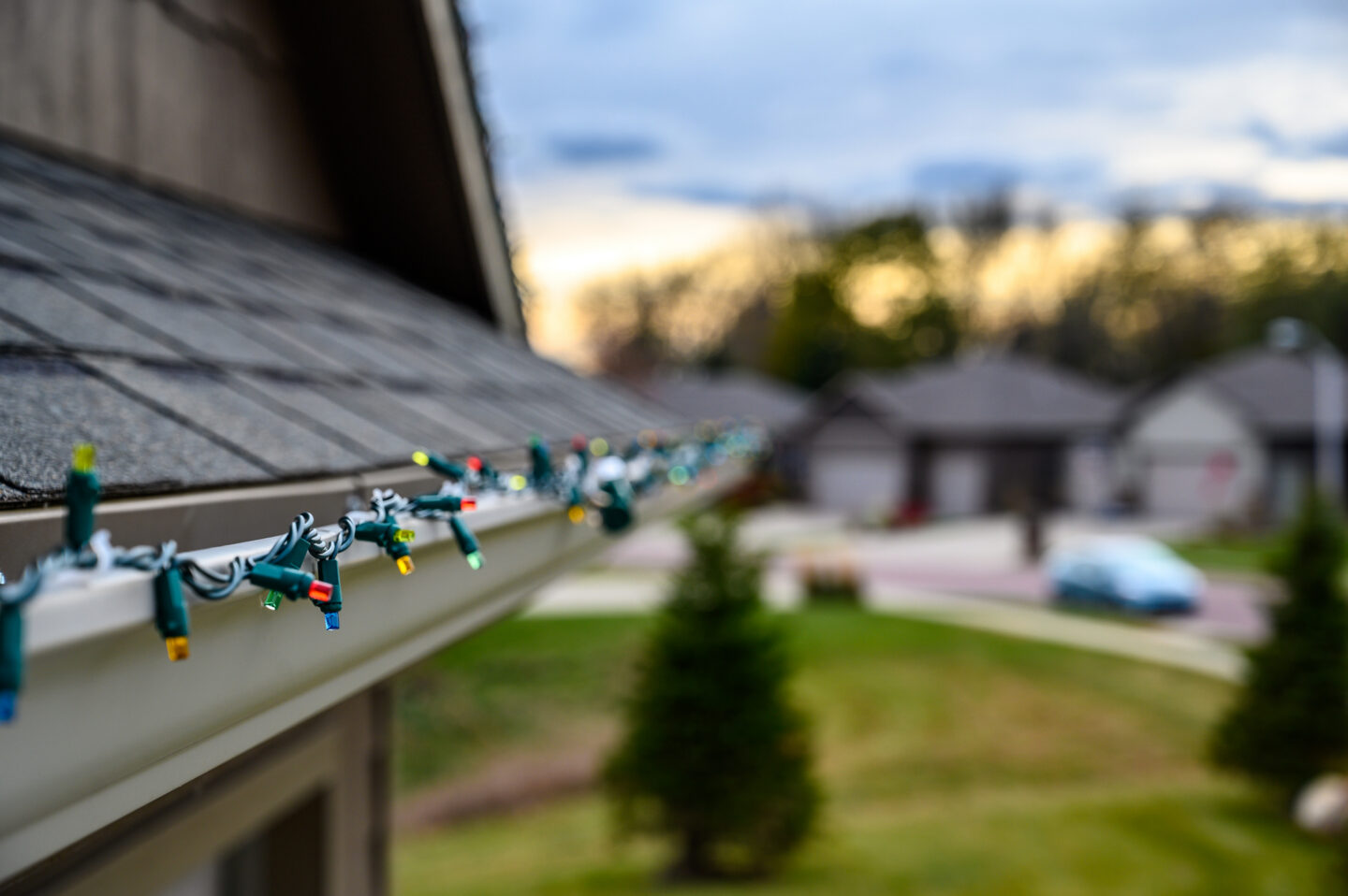 Colorful string lights on house roof during dusk
