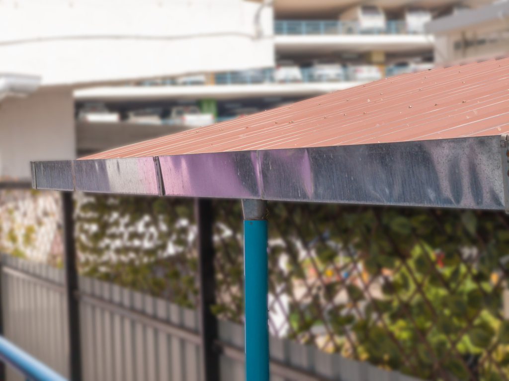 Close-up of a metal roof canopy with urban background
