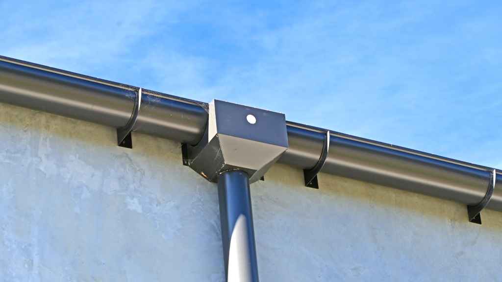 Close-up of a modern rain gutter system on a building roof.