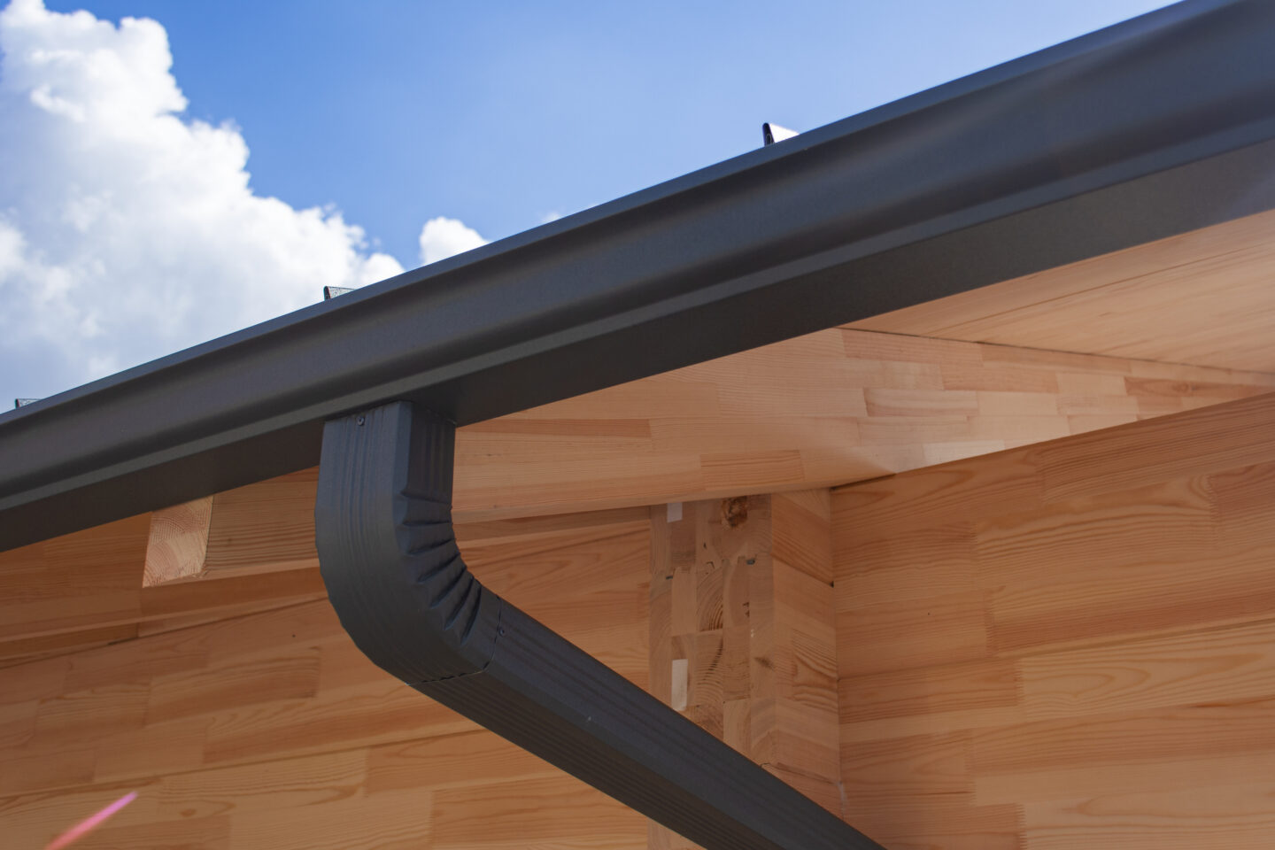 Close-up of a modern roof gutter system on wooden house